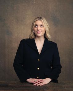 a woman in a black jacket is posing for a photo with her hands on her hips