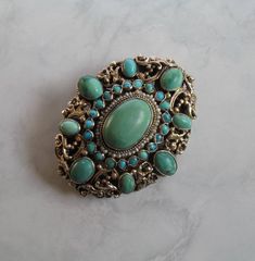 Antique austro hungarian turquoise brooch with seed pearls. The metal is silver gilt. Based on its 800 silver hallmark, it was made between 1867 and 1937. There is a greyhound on it, which indicates that it was made in Budapest. Beautifully engraved on the back. Lovely handwork. Signs of wear commensurate with age can be seen on it, but it is still in very good condition. The center stone is 14.7 x 9.9 mm (0.57 x 0.38 inch) long. Materials: 800 Silver Gemstone: natural turquoise, pearls Measurem Elegant Turquoise Brooches For Collectors, Handmade Vintage Turquoise Brooches, Austro Hungarian, Snake Earrings, Coral Earrings, Gold Snake, Seed Pearl, Akoya Pearls, Antique Earrings