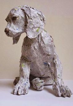 a dog made out of newspaper sitting on top of a table