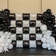 black and white balloons are on display in front of a checkerboard backdrop