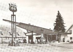 an old black and white photo of a gas station