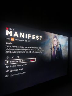 a man standing in front of a large screen with the words maniafest on it