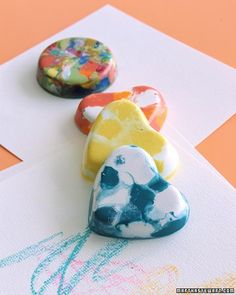 three colorful rocks sitting on top of a piece of paper