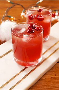 two glasses filled with drinks sitting on top of a table