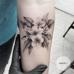 a black and white flower tattoo on the arm