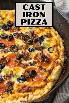 a cast iron pizza with olives, peppers and sausage on it in a pan