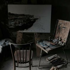 an artist's chair and easel in front of a painting