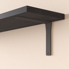 a black shelf mounted to the side of a wall