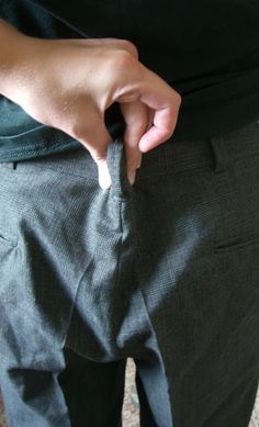 a person is holding their pants open and showing the bottom part of his pants with one hand