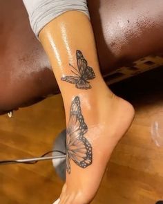 a woman's foot with two butterflies on it