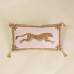 a pink pillow with a cheetah on the front and tasselled edges