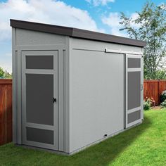 a large gray shed sitting on top of a lush green field