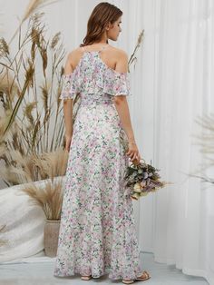 a woman in a floral print dress is holding a bouquet and looking off to the side