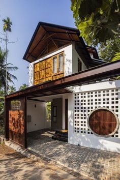 a white house with a wooden door on the outside and brick walkway leading up to it