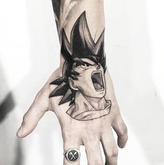 a man's hand with a tattoo on it and an image of gohan