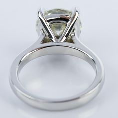 a close up view of a diamond ring on a white surface with the center stone missing