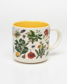 a coffee mug with different types of plants on it