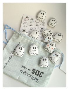 several buttons with ghost faces on them sitting next to a bag