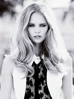 black and white photograph of a woman with long blonde hair wearing a neck tie in front of a tree