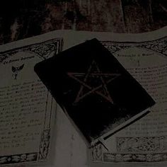 an old book with a pentagramil on it sitting on top of a table