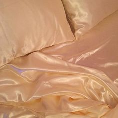 an unmade bed with white sheets and pillowcases on top of each other