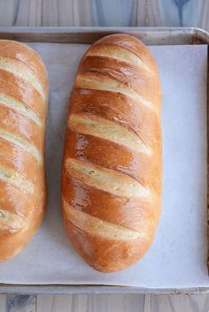 two loaves of bread sitting on top of a baking pan next to each other