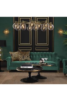 a living room filled with green couches and chairs next to a wall mounted chandelier