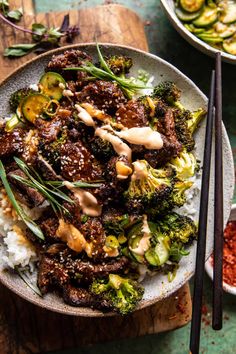 a bowl filled with beef and broccoli on top of rice