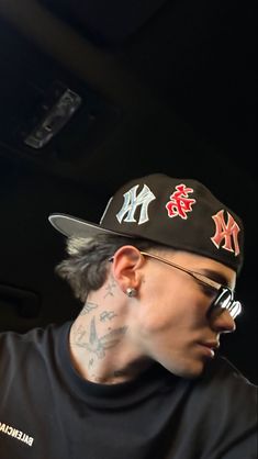 a man with tattoos wearing a baseball cap