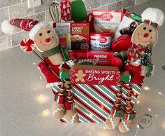 a christmas gift basket filled with cookies, candy and other holiday treats on a kitchen counter