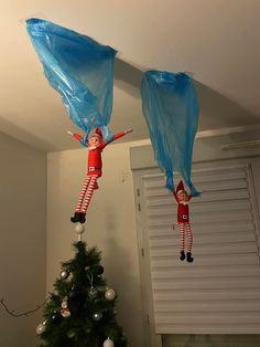 two elfs hanging upside down from the ceiling