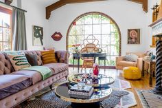 a living room filled with furniture and a fire place in front of a large window