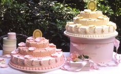 three tiered wedding cakes are displayed on a table with pink ribbon and ribbons around them