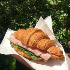 a croissant sandwich with ham and lettuce