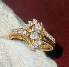 a gold ring with two rows of diamonds on it, sitting on top of a white cloth