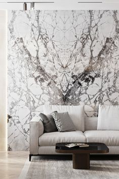 a living room with marble wallpaper and couches in front of the sofa is a coffee table