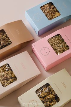 four boxes with different types of granola in them sitting on a counter top next to each other