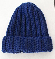 a blue knitted hat sitting on top of a white table