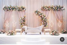 a white couch sitting on top of a table next to a set of chairs and flowers