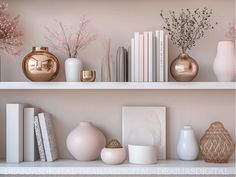 there are many vases and books on the shelves in this room, one is pink