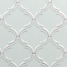 a white tile with an intricate design on the back wall and bottom part of it