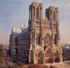 the large cathedral has many windows on it's sides and is surrounded by trees