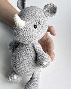 a crocheted stuffed animal being held by a hand