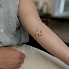 a woman with a small flower tattoo on her arm