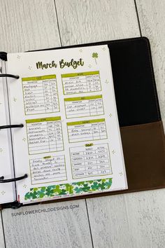 a planner is open on top of a wooden table with shamrocks and the words march budget written in it