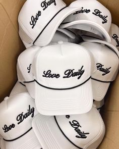 a box filled with white hats that say love daddy and have black lettering on them