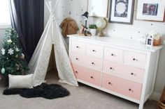 a teepee tent sitting next to a christmas tree in a room with polka dots on the walls