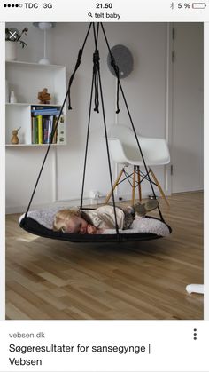 a small child laying in a swing chair