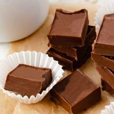 several pieces of chocolate sitting next to each other on top of a table with paper cups