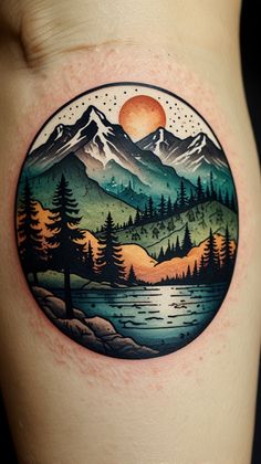 a woman's thigh with a tattoo on it that has mountains and trees in the background